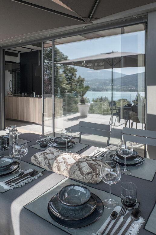 Salle à manger extérieure : Espace de salle à manger extérieur avec une vue magnifique sur le lac et les montagnes à Annecy, mise en valeur par Blue1310.