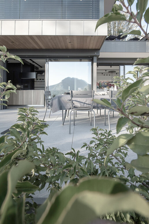 Terrasse extérieure avec vue sur le lac : Photo d'une terrasse élégante avec mobilier de jardin et vue sur le lac d'Annecy.