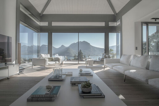 Terrasse extérieure avec vue sur le lac : Photo d'une terrasse élégante avec mobilier de jardin et vue sur le lac d'Annecy.