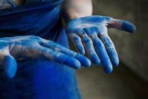 Photographie main de peintre avec des pigments bleus à Annecy en Haute-Savoie