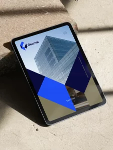 Conception de site web pour Geomat, réalisée par un graphiste freelance à Annecy, montrant une tablette avec un design moderne et professionnel pour une entreprise de construction.